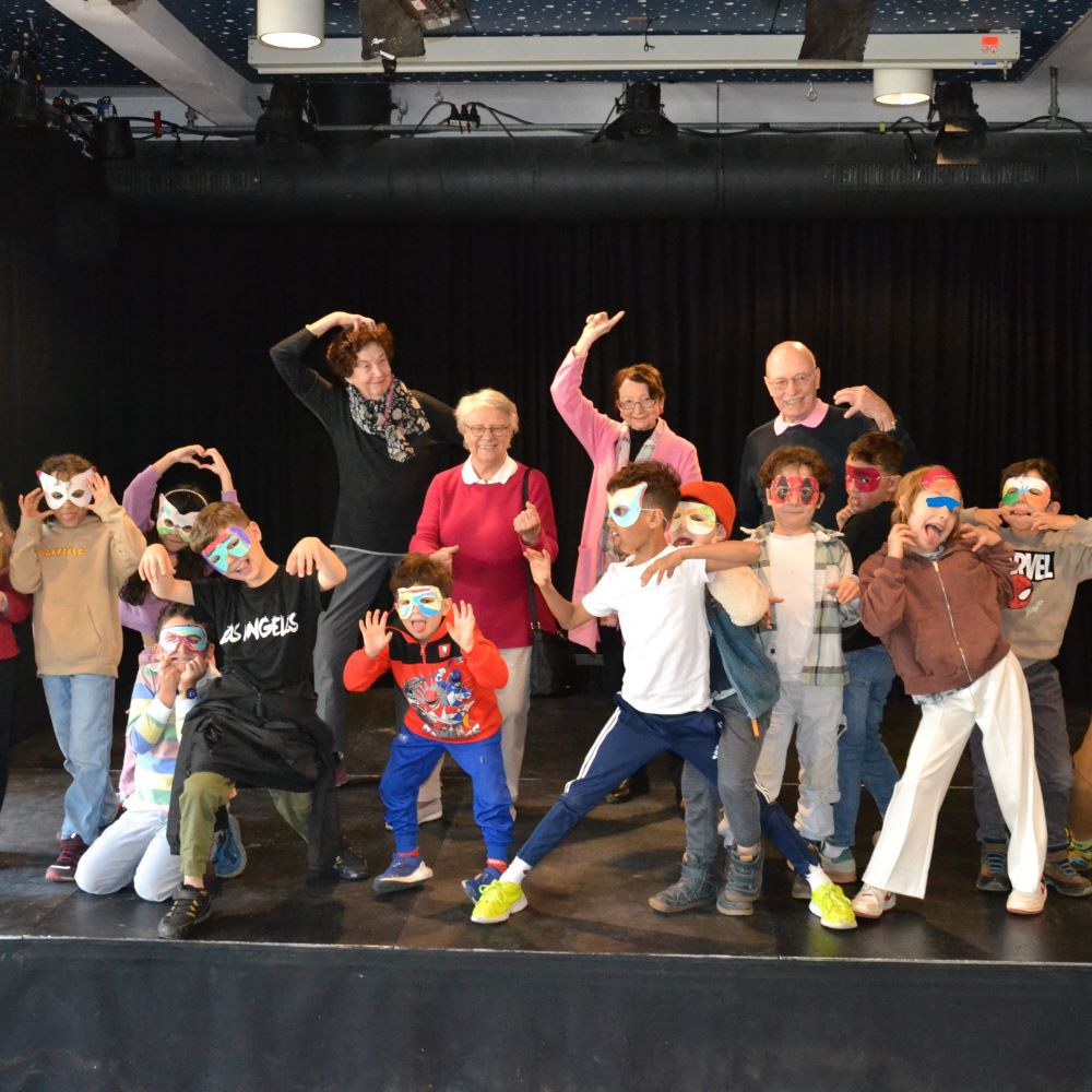 Die Kinder der Forsmann-Schule tragen Masken und gucken vor der Bühne gerunter